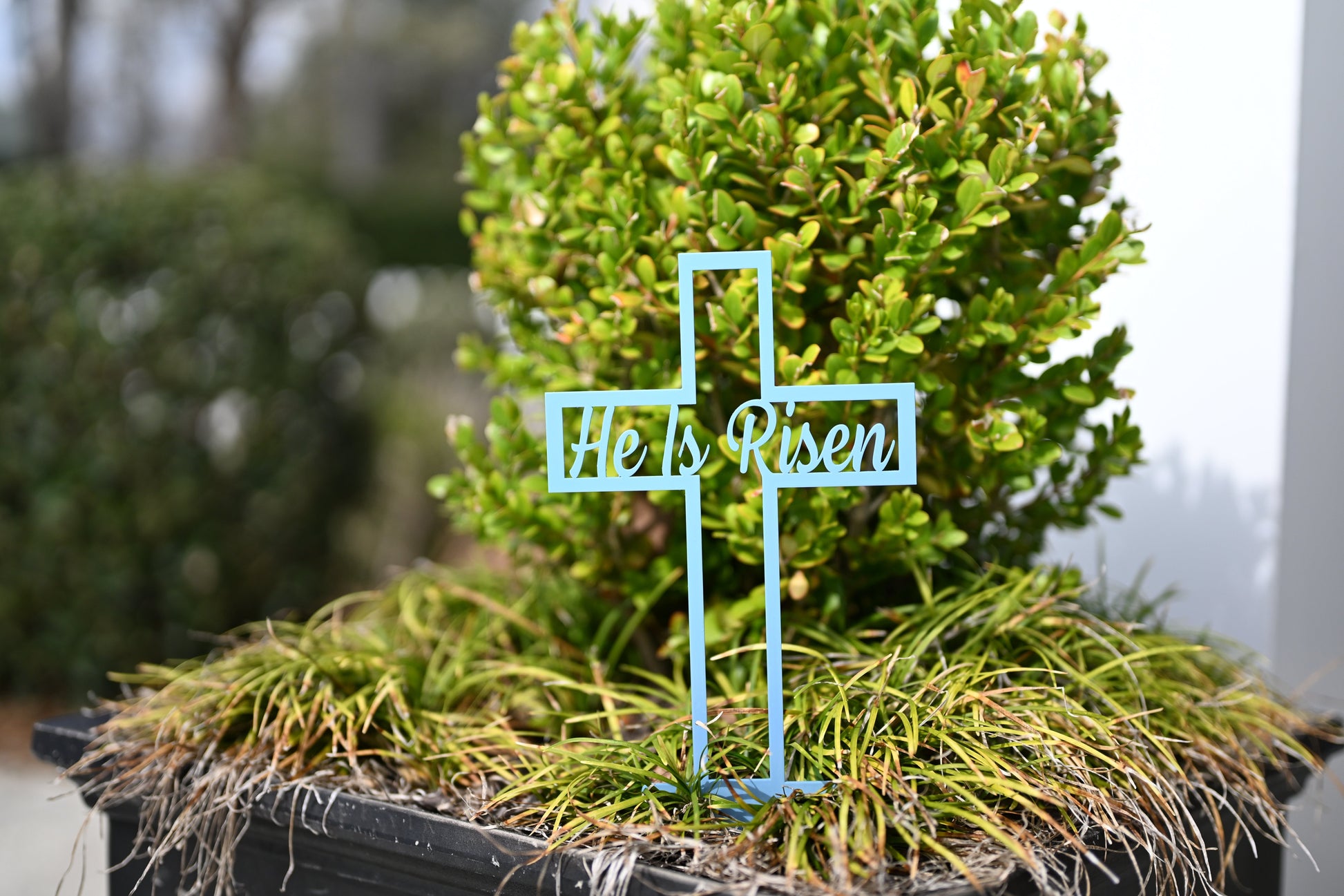 Pastel blue He Is Risen Cross metal garden sign by Lewis Design Company, outdoor Easter yard and patio garden art.