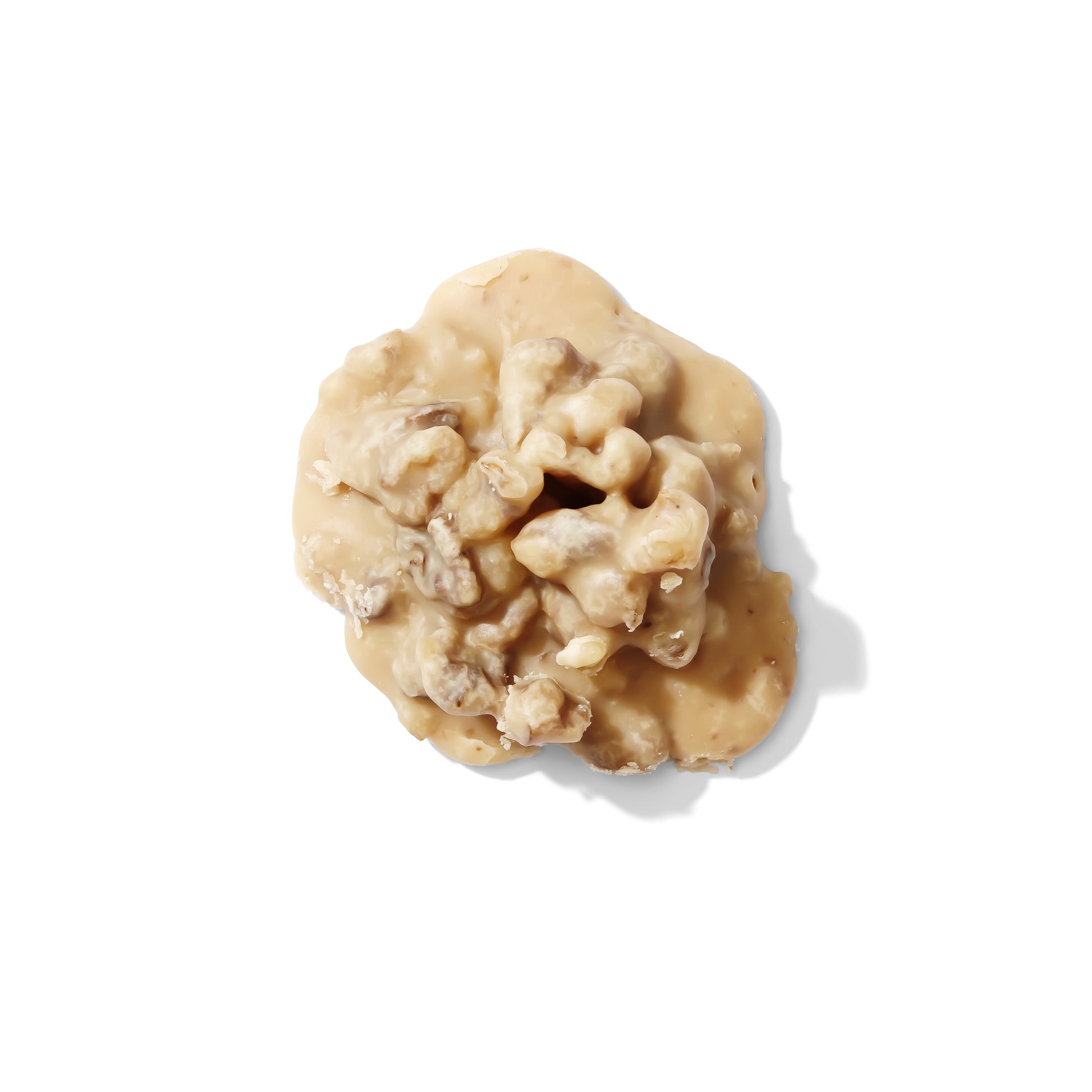 Six creamy walnut pralines from Louisiana Candy Company, close-up of golden caramel and chopped walnuts on a white background.