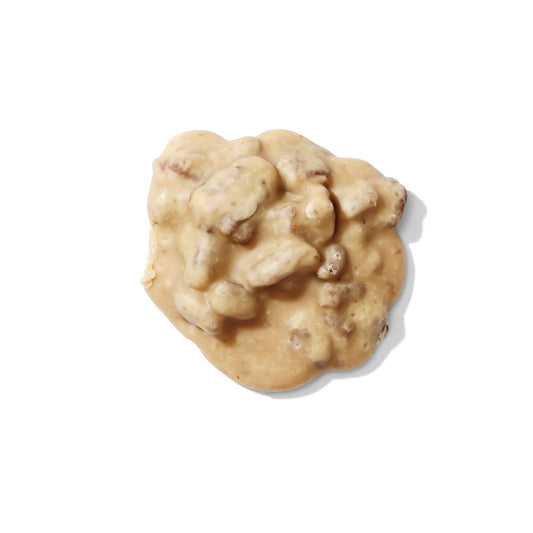 Six classic pecan pralines from Louisiana Candy Company arranged on a plate, showcasing their glossy caramel coating and pecan filling.