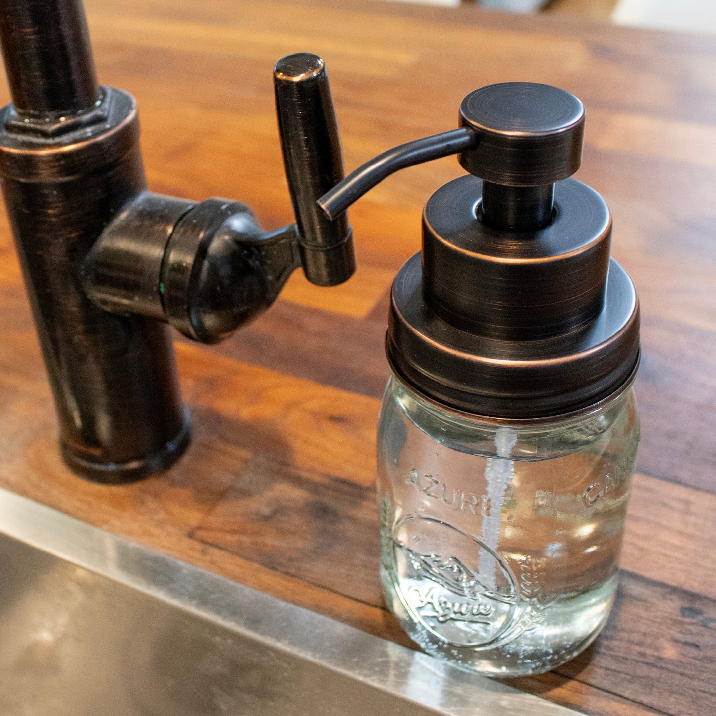 Stainless steel oil-rubbed bronze foaming soap pump dispenser for Mason jars, suitable for kitchen or bathroom use.