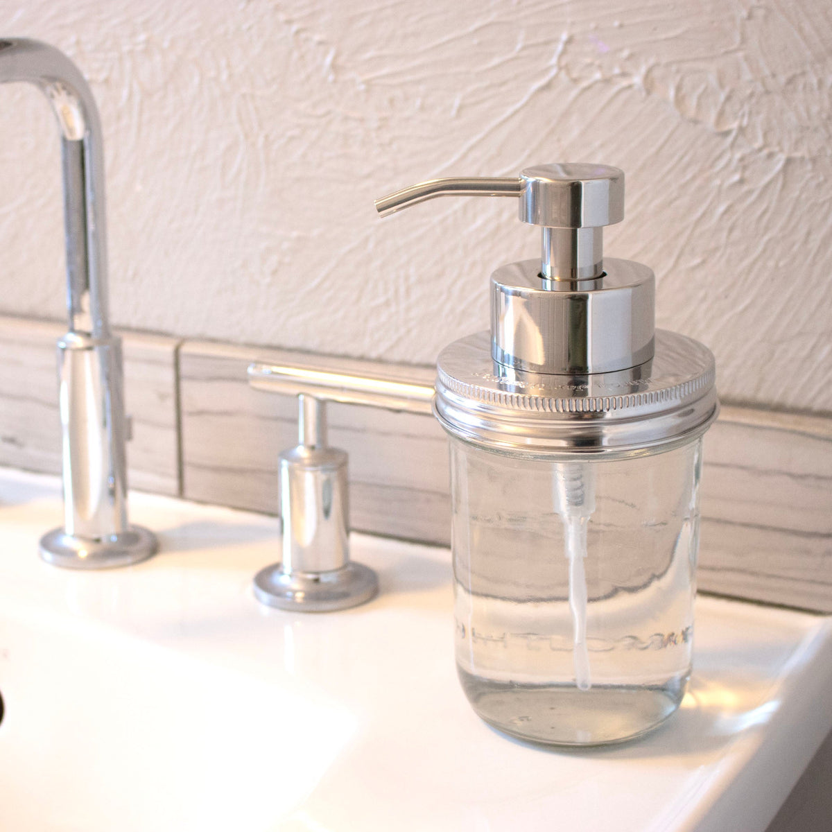 Stainless steel foaming soap pump dispenser attached to a wide-mouth Mason jar with a threaded lid, 16oz size, for Mason Jar Lifestyle.