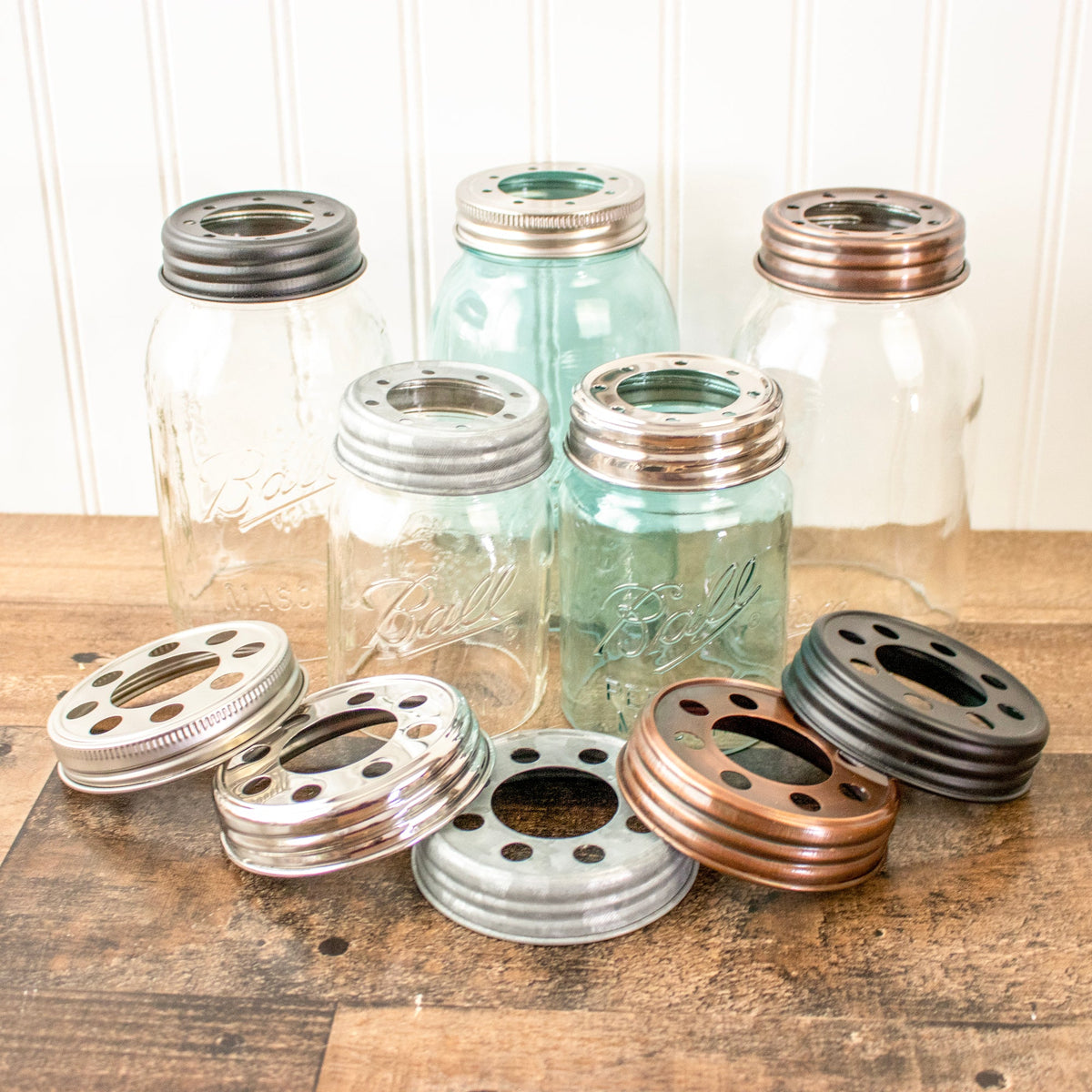 Stainless steel and black oil-rubbed bronze Mason Jar Lifestyle lighting lid for pendant fixtures with bulbs and wide-mouth jar.