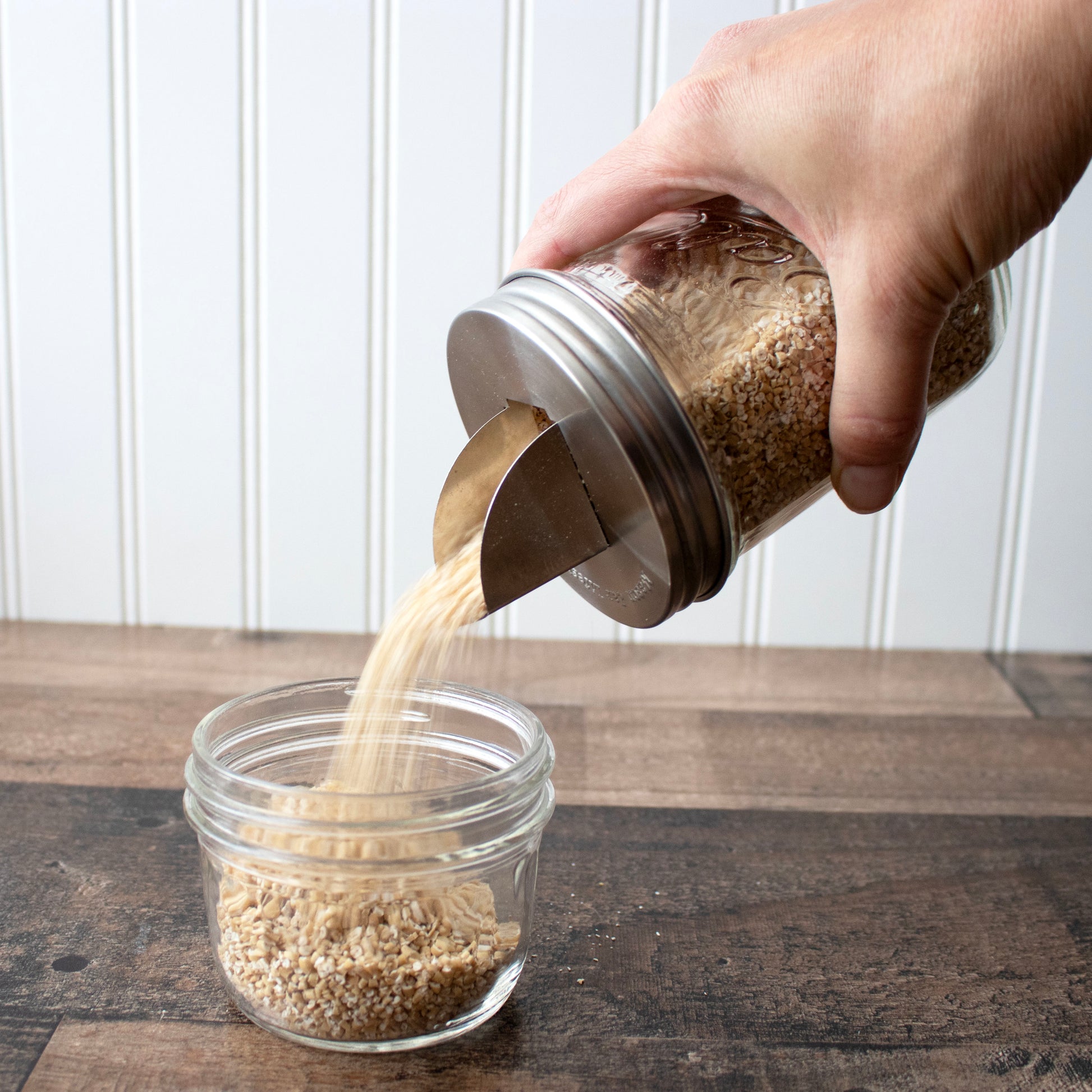 Two stainless steel grain dispenser lids for mason jars, compatible with regular-mouth Mason Jars, by Mason Jar Lifestyle.