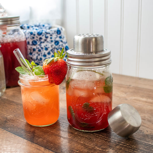 Mason Jar Lifestyle stainless steel cocktail shaker lid with band, shown on a mason jar with strawberries, perfect for compact drink mixing