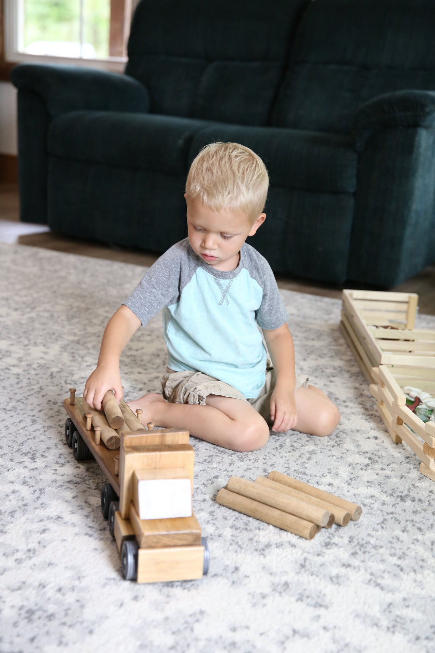 Amish-made wooden log semi truck toy with removable logs, featuring detailed wooden construction and realistic truck design.