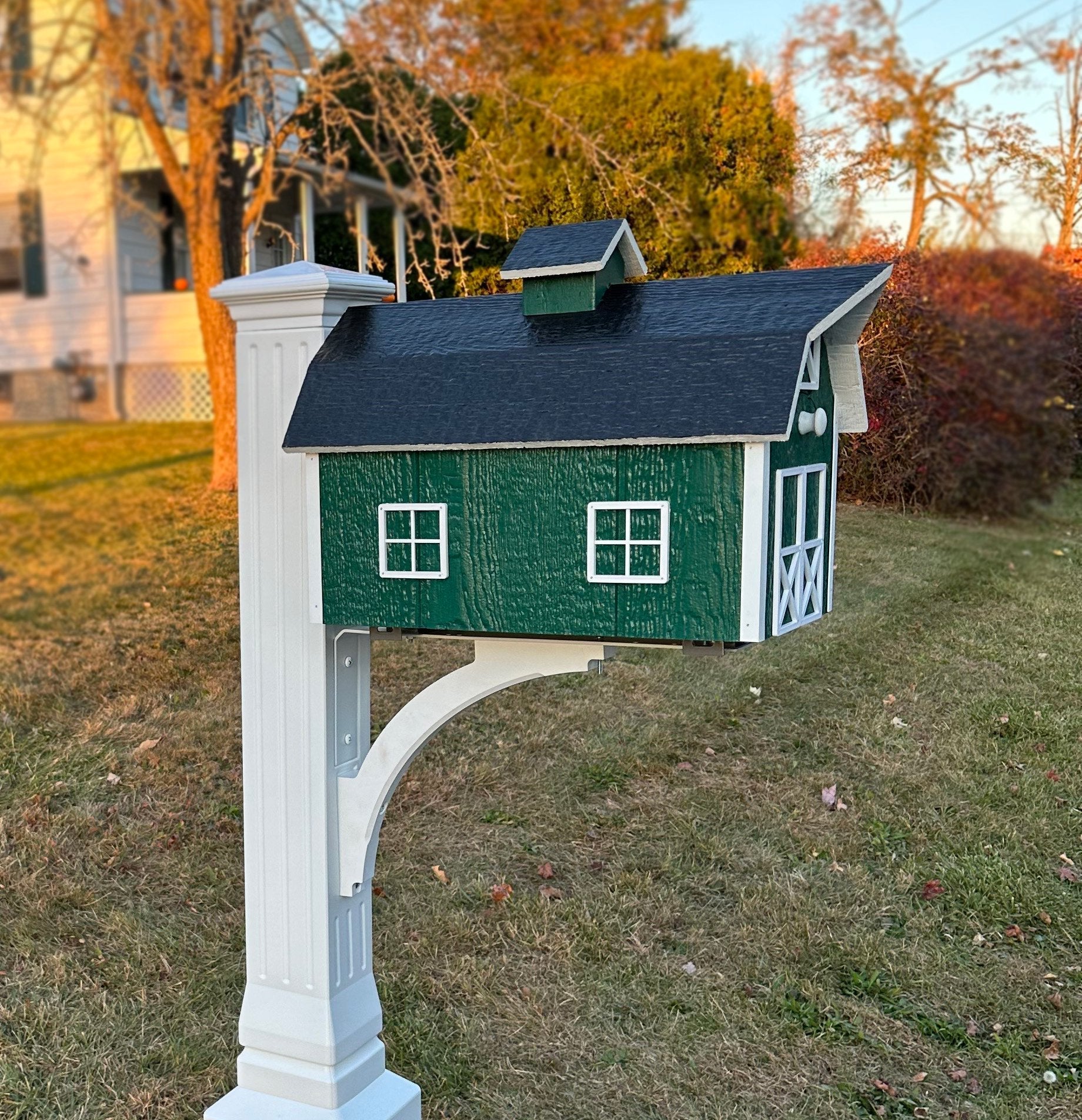 Amish-made wooden Dutch barn style mailbox mounted on a post, crafted for durable outdoor home improvement use.