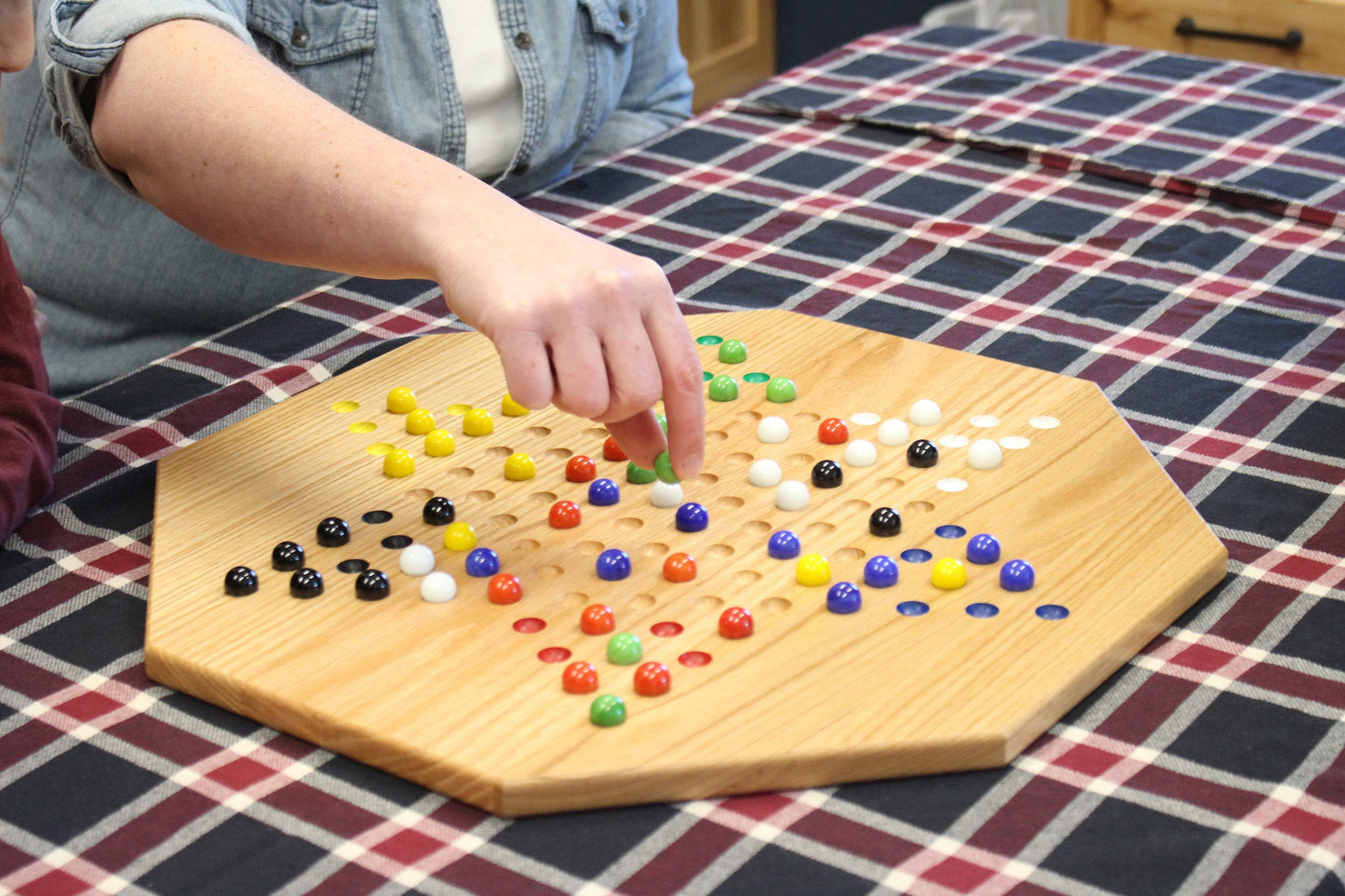 Hand-painted oak wooden Chinese checkers board game with colorful star pattern, 19-inch wide, crafted by AmishToyBox.com.