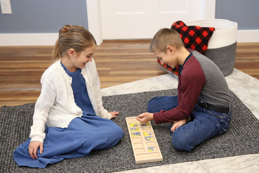 Solid oak wood Mancala board game set with marbles, handcrafted by AmishToyBox.com, featuring a smooth, polished surface and carved details.