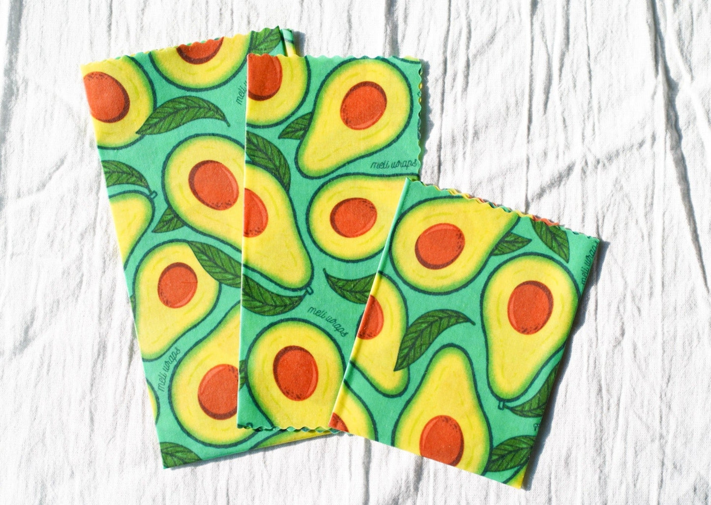 Set of three Meli Wraps beeswax food wraps with avocado print in small, medium, and large sizes for food storage.