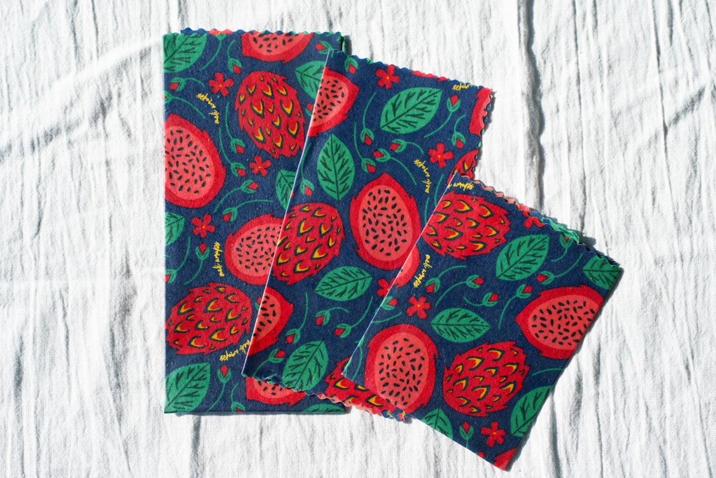 Set of Meli Wraps beeswax food wraps with vibrant dragonfruit print in small, medium, and large sizes.