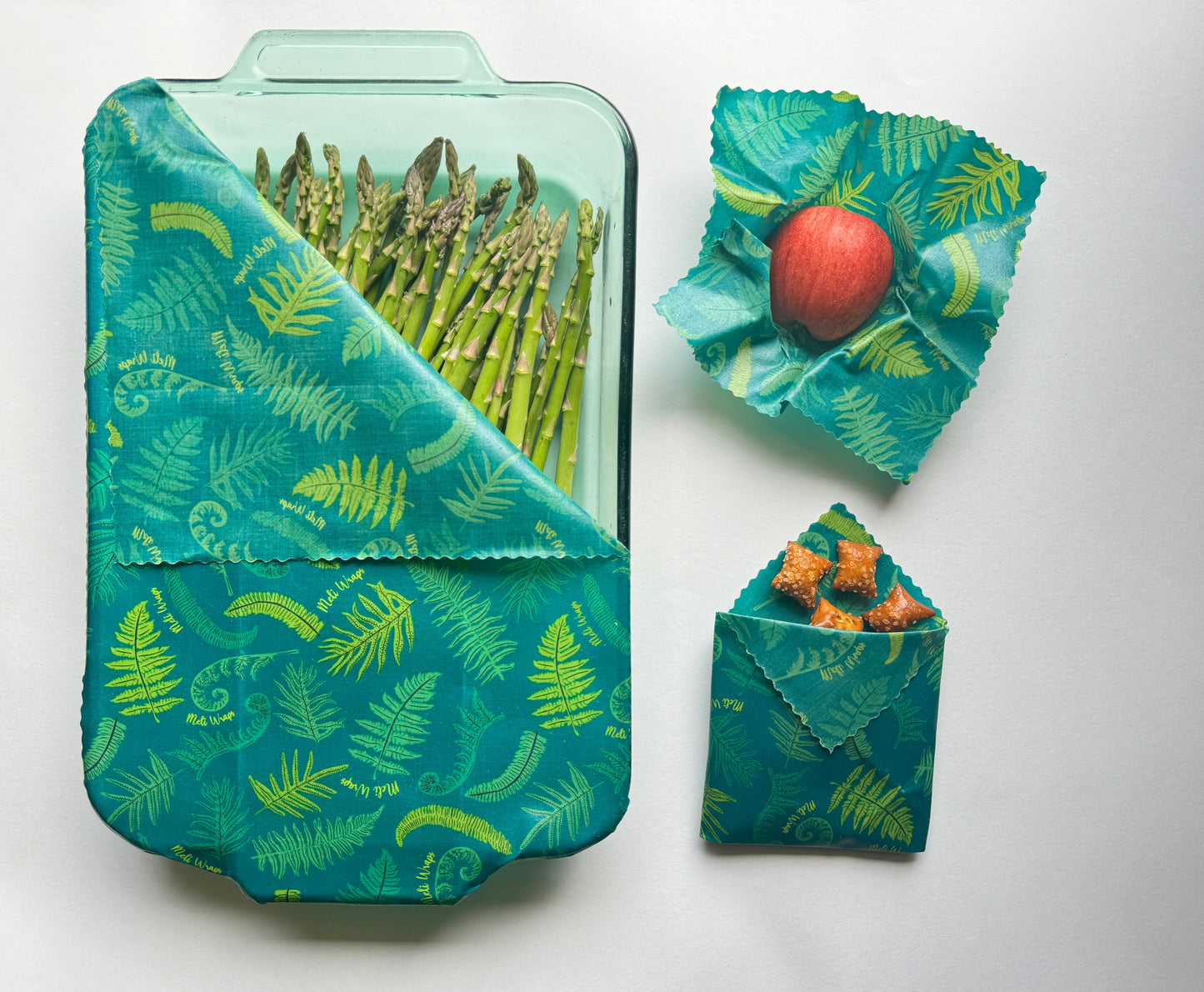 Set of three Meli Wraps beeswax food wraps with fern print in small, medium, and large sizes for food storage and wrapping.