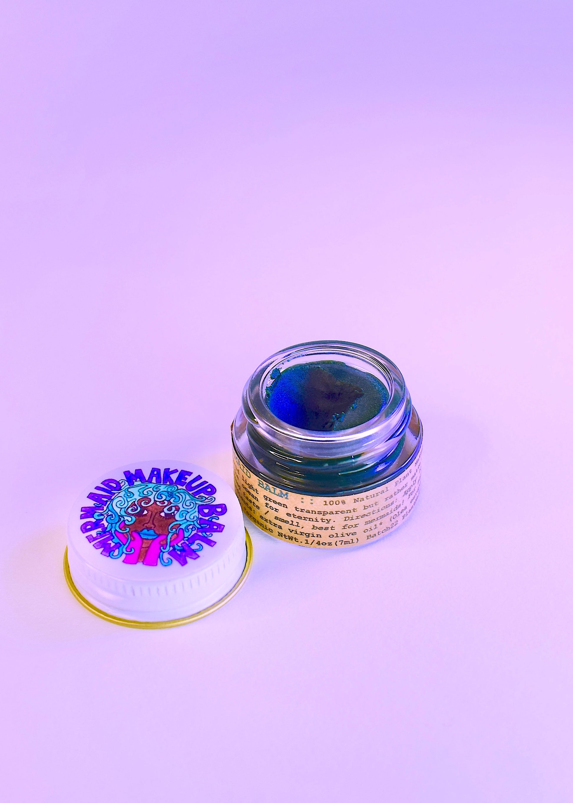Plant Makeup Mermaid Makeup Balm in a decorative container with shimmering, mermaid-inspired packaging and colorful, creamy balm inside.