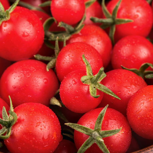 Bright red Sweetie Tomato from MIgardener, showcasing its round shape and smooth skin on a white background.
