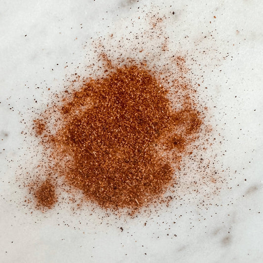 Olive Branch Oil & Spice mild chili powder blend in a glass jar, featuring bright red chili flakes and seasoned spice mix close-up.