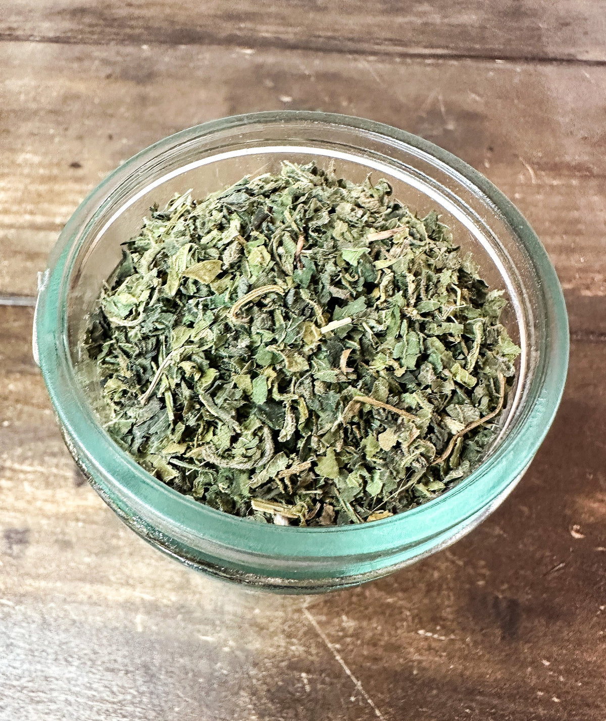 Small jar of dried nettle herbs from herbalroseapothecary, stored in a compact herb jar with a clear label.
