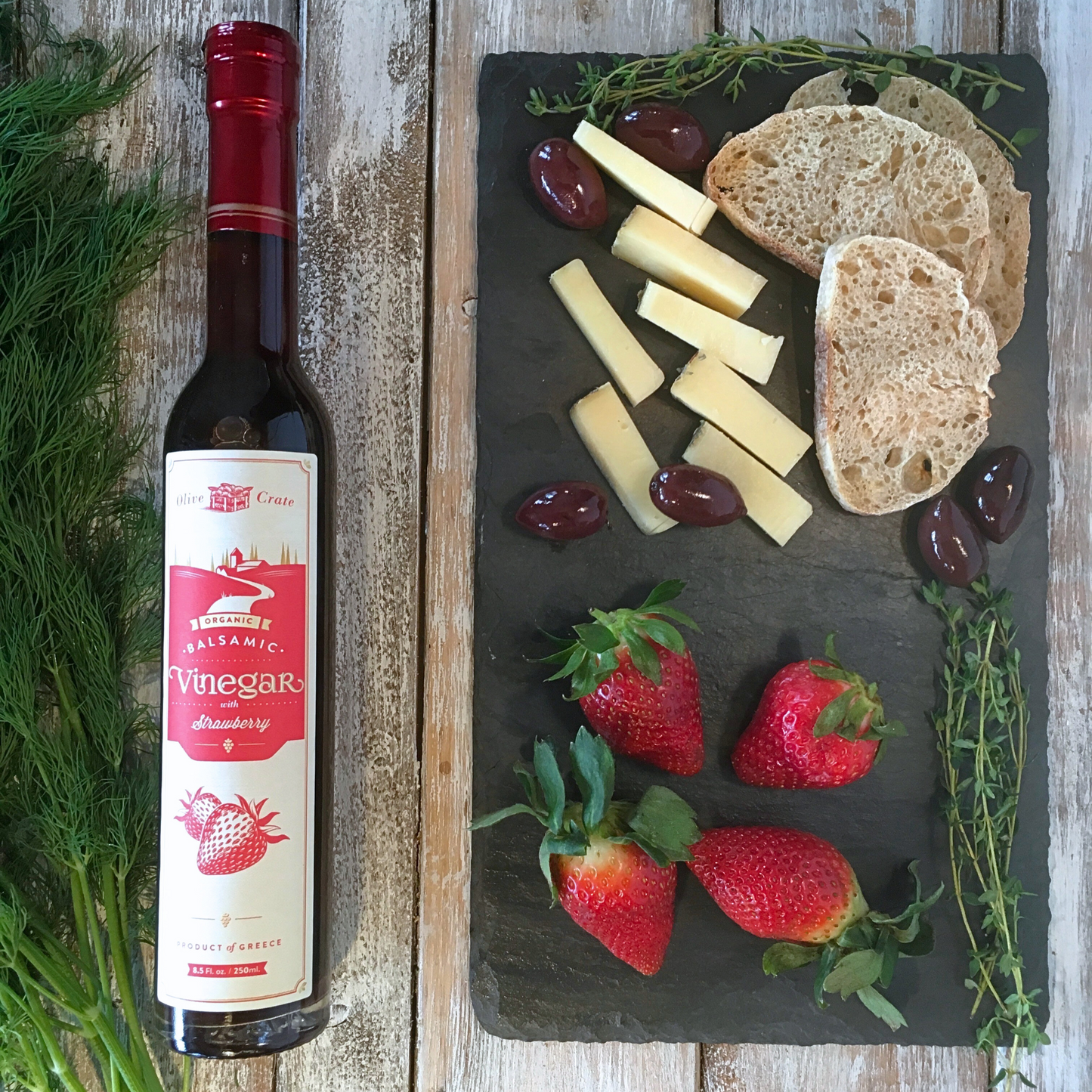 Olive Crate organic balsamic vinegar with strawberry in a glass bottle, showcasing a rich dark color and fresh strawberry infusion.
