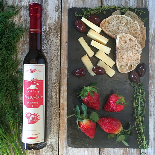 Olive Crate organic balsamic vinegar with strawberry in a glass bottle, showcasing a rich dark color and fresh strawberry infusion.