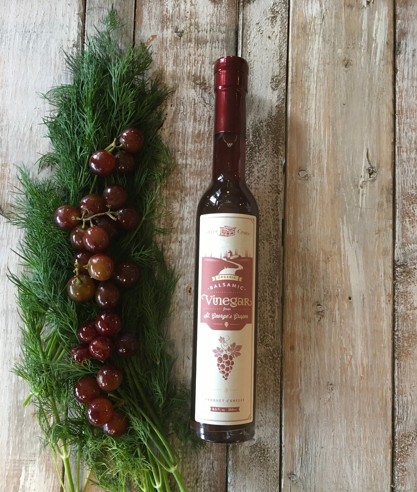 Organic balsamic vinegar from St. George's grapes by Olive Crate, shown in a clear glass bottle with dark, rich liquid.