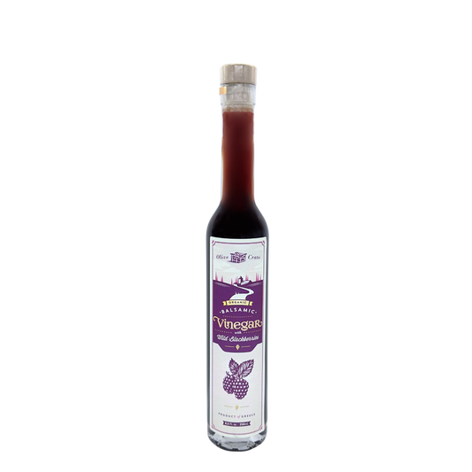 Bottle of Olive Crate organic balsamic vinegar with wild blackberry flavor, showing dark vinegar and fresh blackberries.