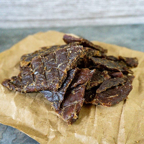 Original Nebraska Star Beef Jerky slab in a 1.5 oz portion, showcasing the dry, seasoned beef slices on a cutting board.