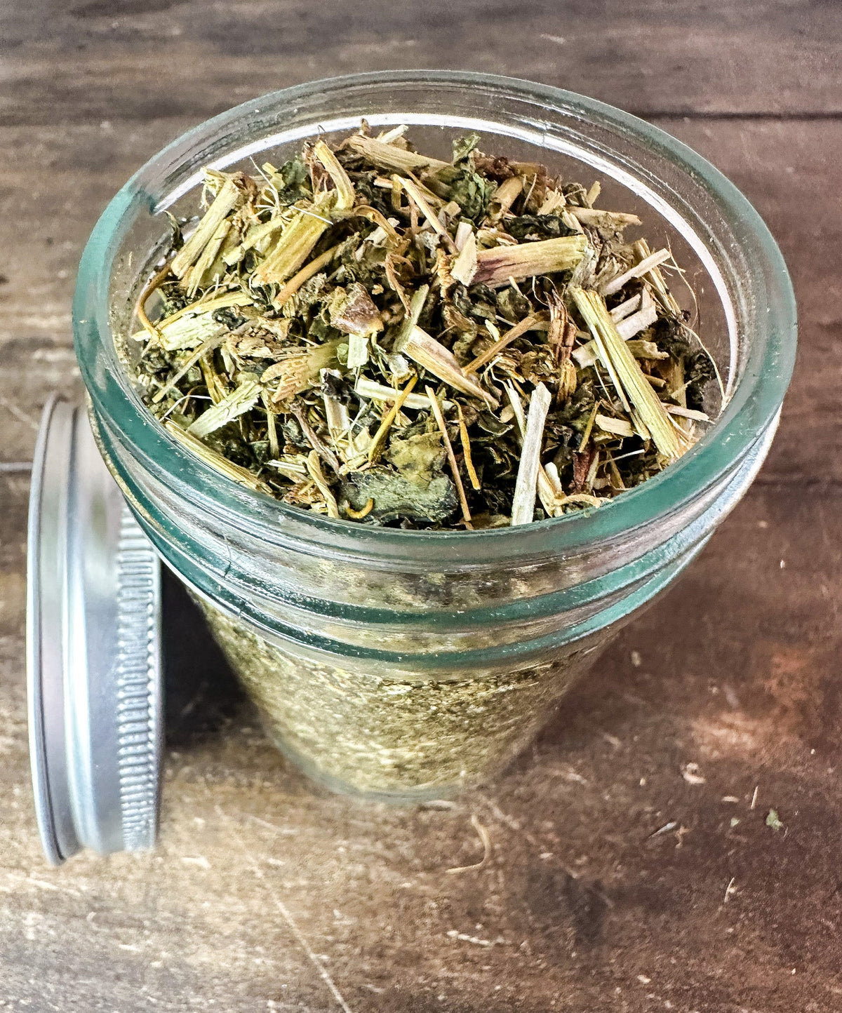 Small jar of dried passion flower herbs in a herbalroseapothecary herb jar, showcasing herbal packaging and dried passion flower leaves