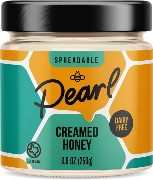Creamed honey from Pearl Honey Spreads in a jar, showcasing smooth, spreadable honey with a creamy texture.