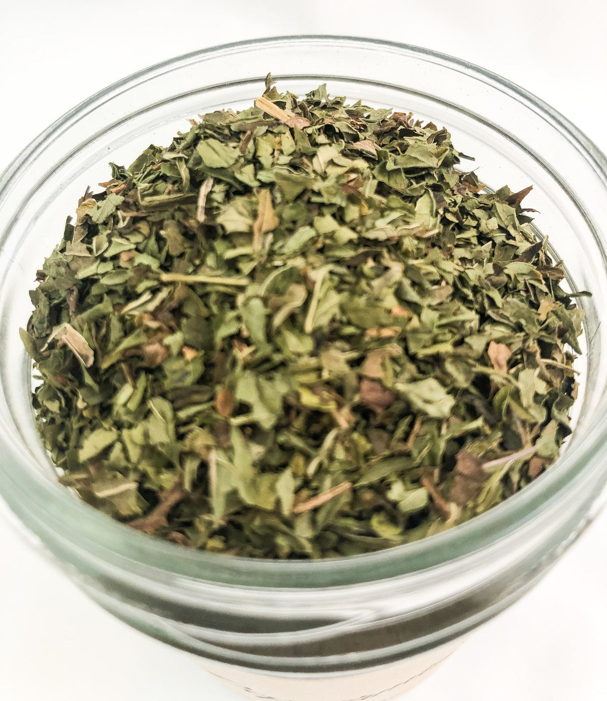 Small herbal herb jar containing dried peppermint from Herbalroseapothecary, with a white lid and clear glass body.