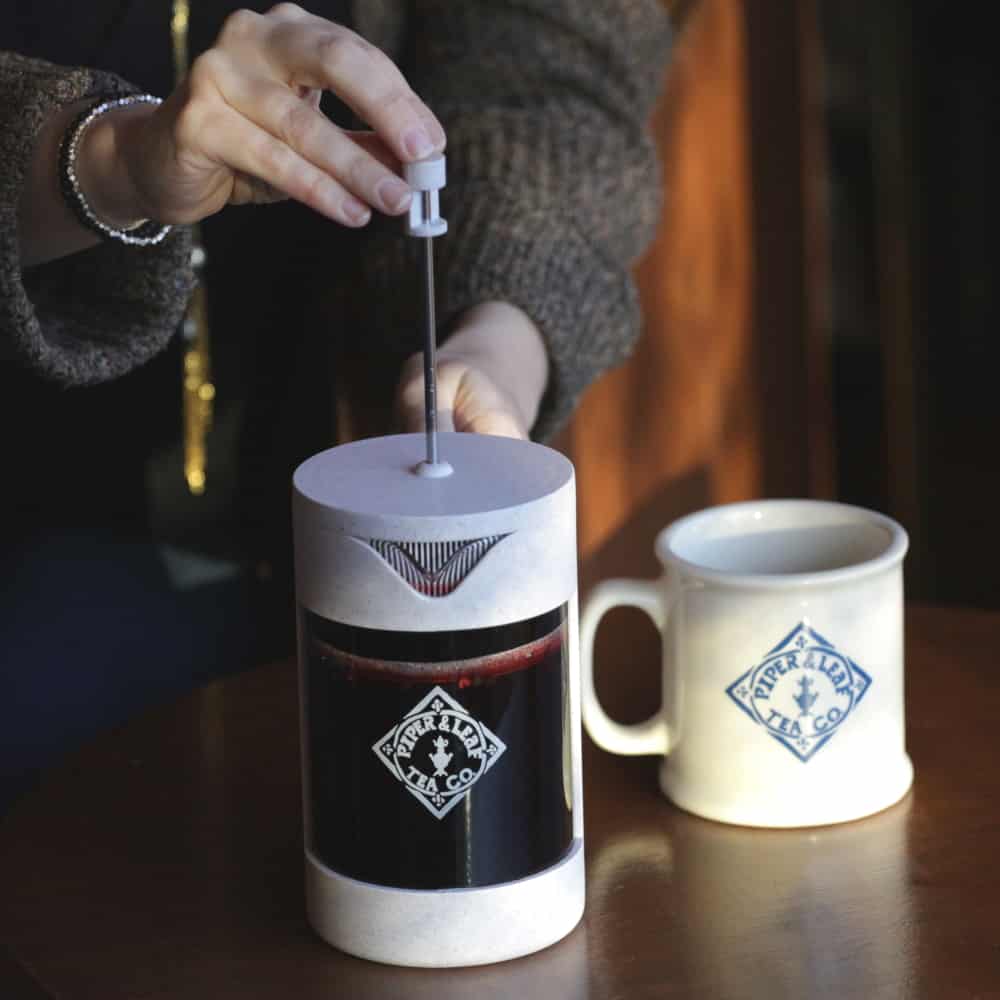 Piper Press Brew Kit from Piper and Leaf Tea Co., includes tea brewing accessories on a front porch setting, perfect for gift-giving.