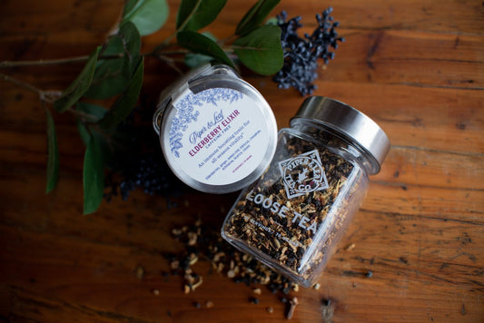 Glass jar of Piper and Leaf Elderberry Elixir loose leaf tea with 30 servings, showing the herbal tea leaves inside.