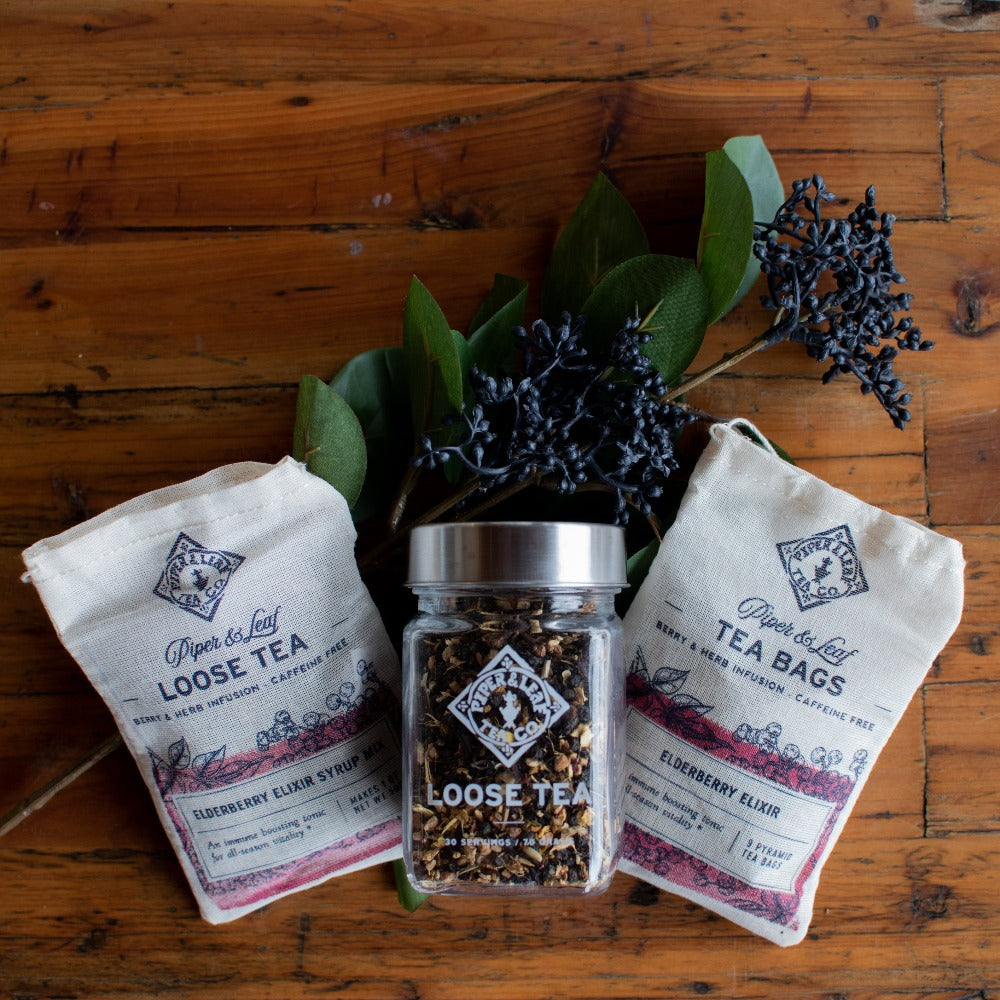 Glass jar of Piper and Leaf Elderberry Elixir loose leaf tea, showing dried elderberries and tea leaves inside.