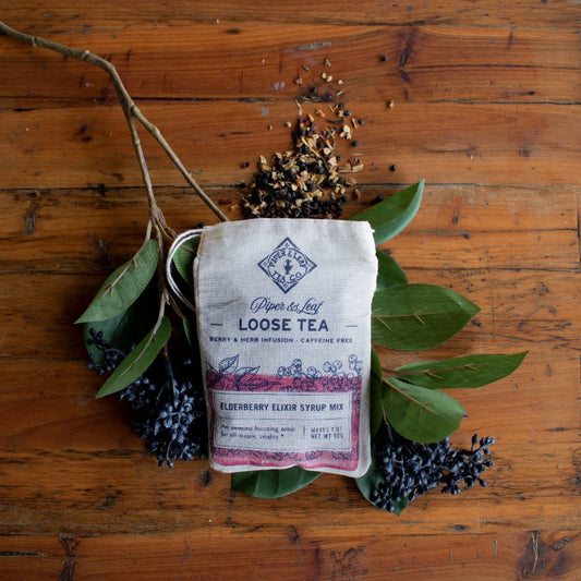Loose leaf Elderberry Elixir Tea by Piper and Leaf Tea Co., vibrant dried elderberries and tea leaves in a clear jar.