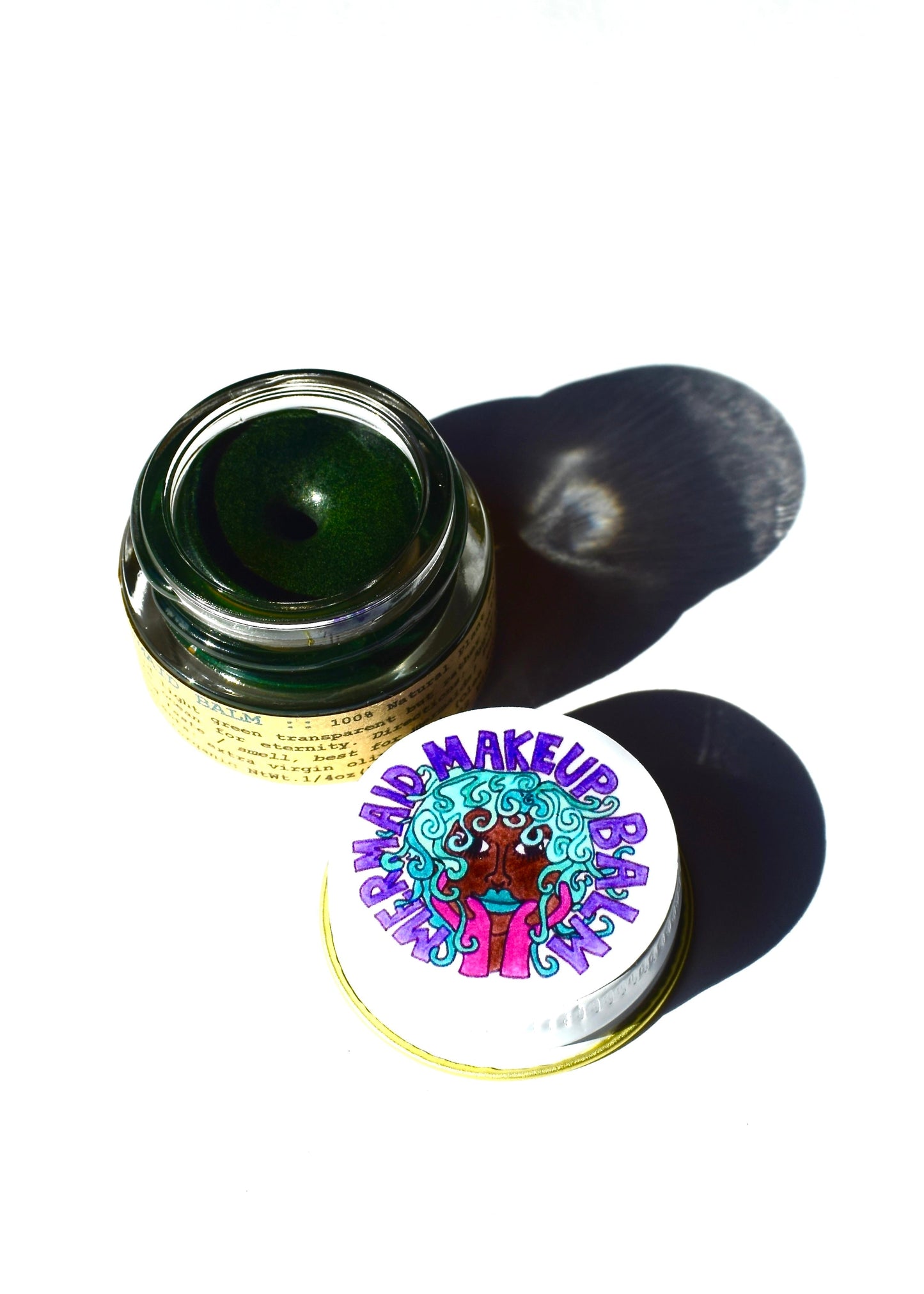 Plant Makeup Mermaid Makeup Balm in a jar with colorful, shimmering mermaid-inspired makeup balm visible inside.