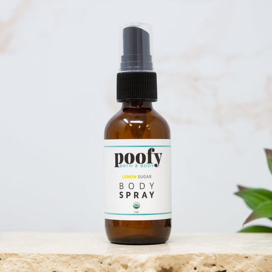 Poofy Organics Lemon Sugar Organic Body Spray featuring a clear bottle with a yellow label and spray nozzle.