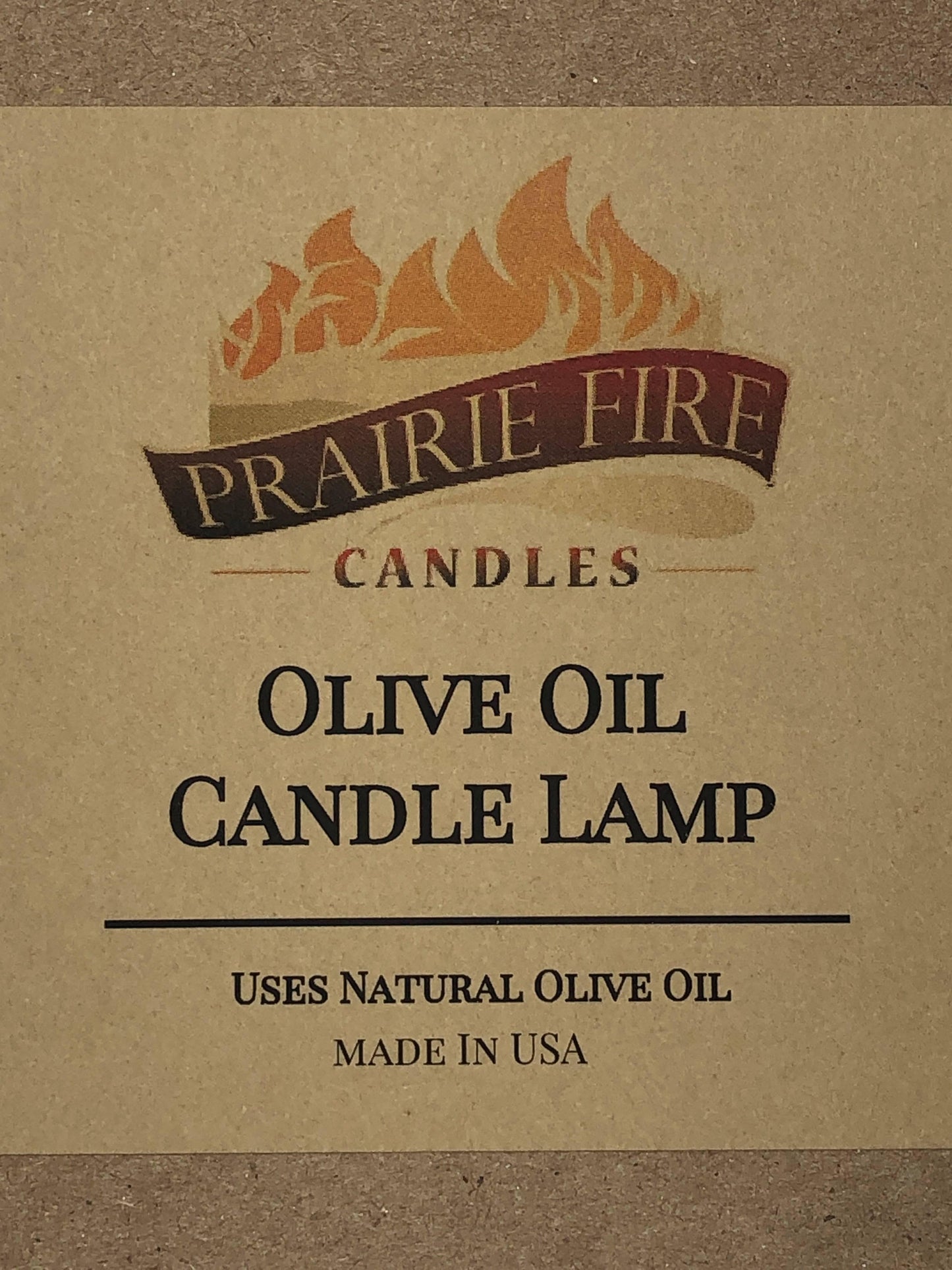 Olive oil candle lamp by Prairie Fire Tallow, used as emergency backup during power outages, with a rustic design and flame.