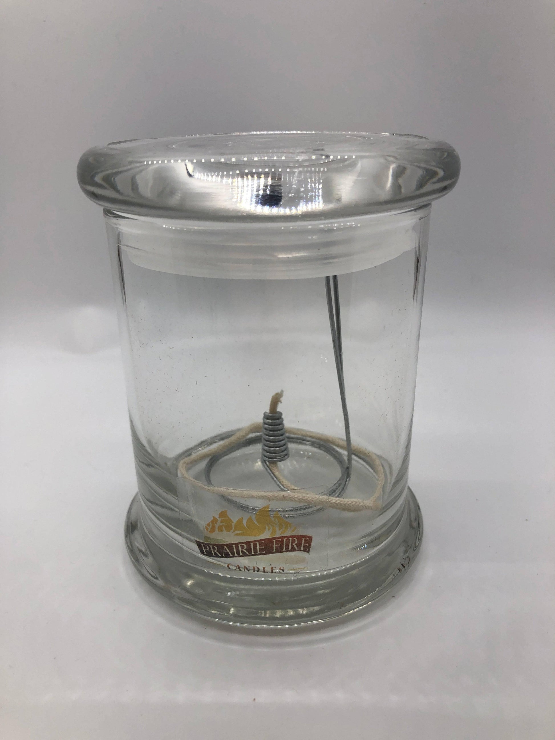 Olive Oil Candle Lamp by Prairie Fire Tallow, used as an emergency backup during power outages, with a rustic design and glass container.