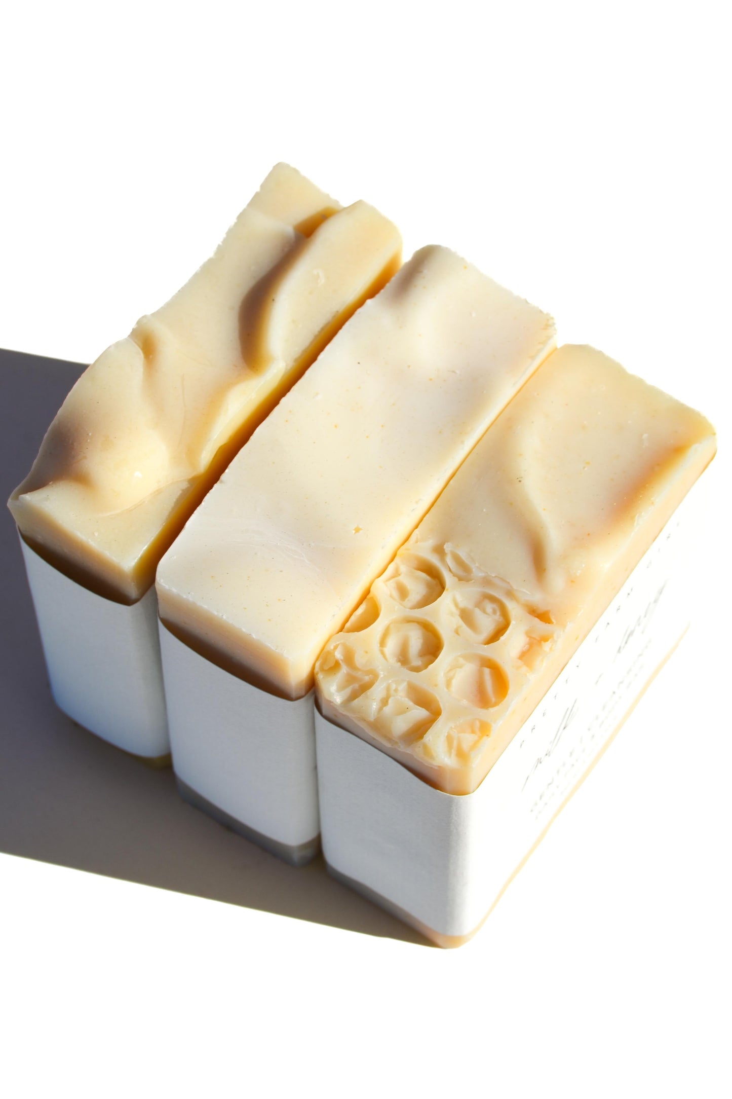 Three fragrance-free handmade soap bars with tallow and goat milk from Pretty Farm Girl, showing natural, rustic soap slices.