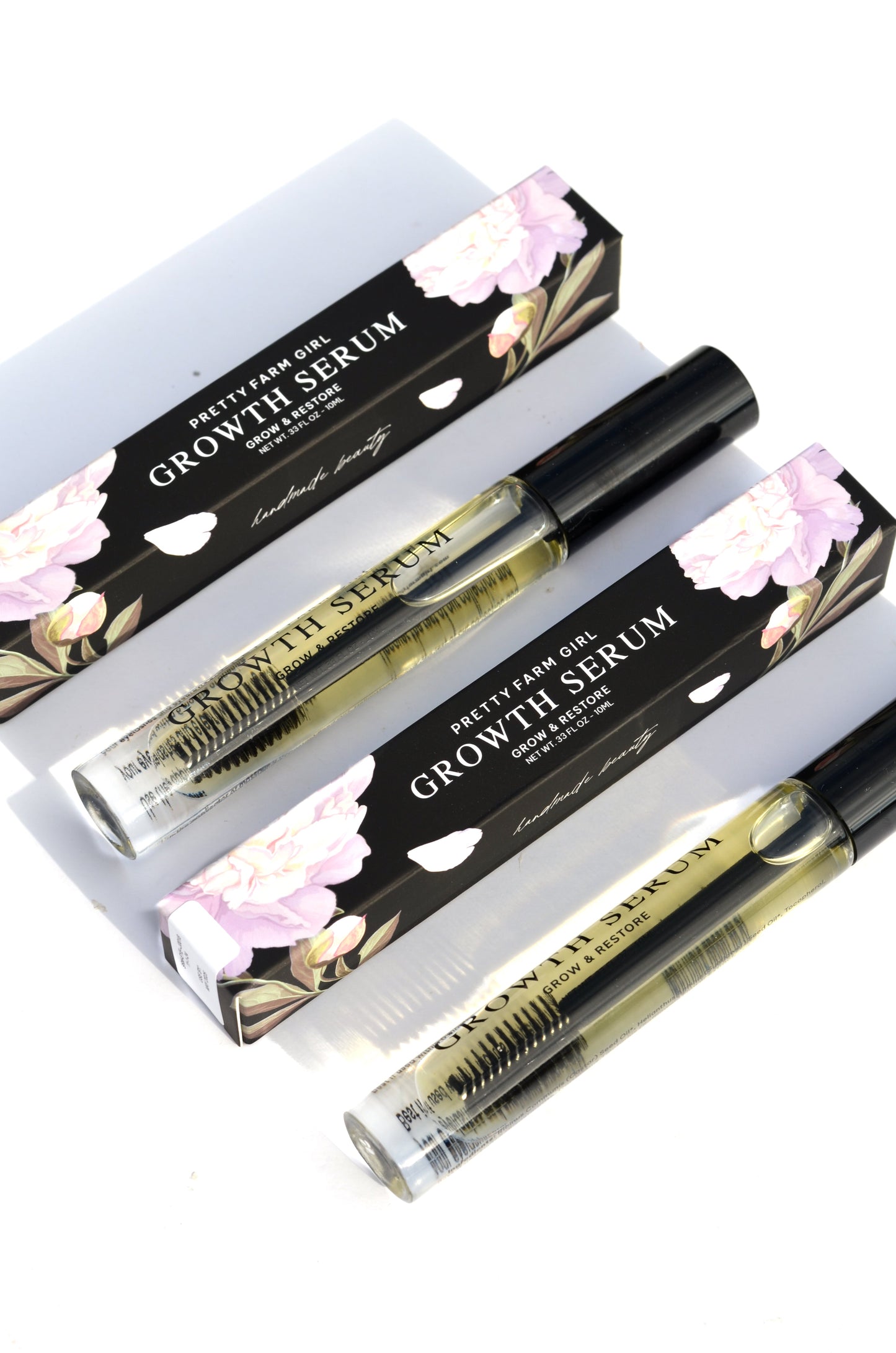 Pretty Farm Girl eyelash and eyebrow growth serum bottle, showing the product label and applicator.