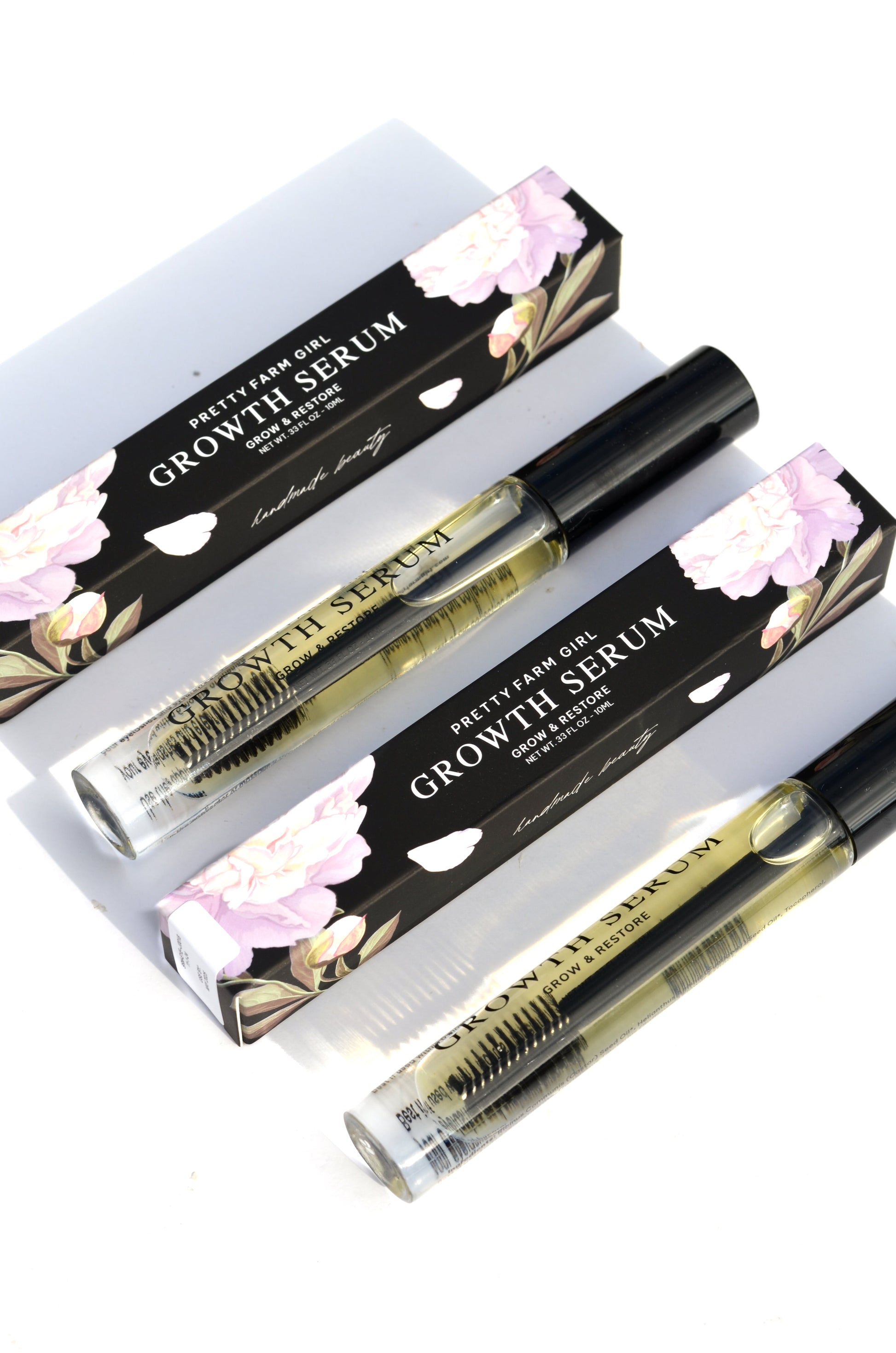 Pretty Farm Girl eyelash and eyebrow growth serum bottle, showing the product label and applicator.