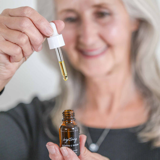 Pretty Farm Girl Brightening Face Serum with Vitamin C, showcasing the sleek bottle and vibrant label.