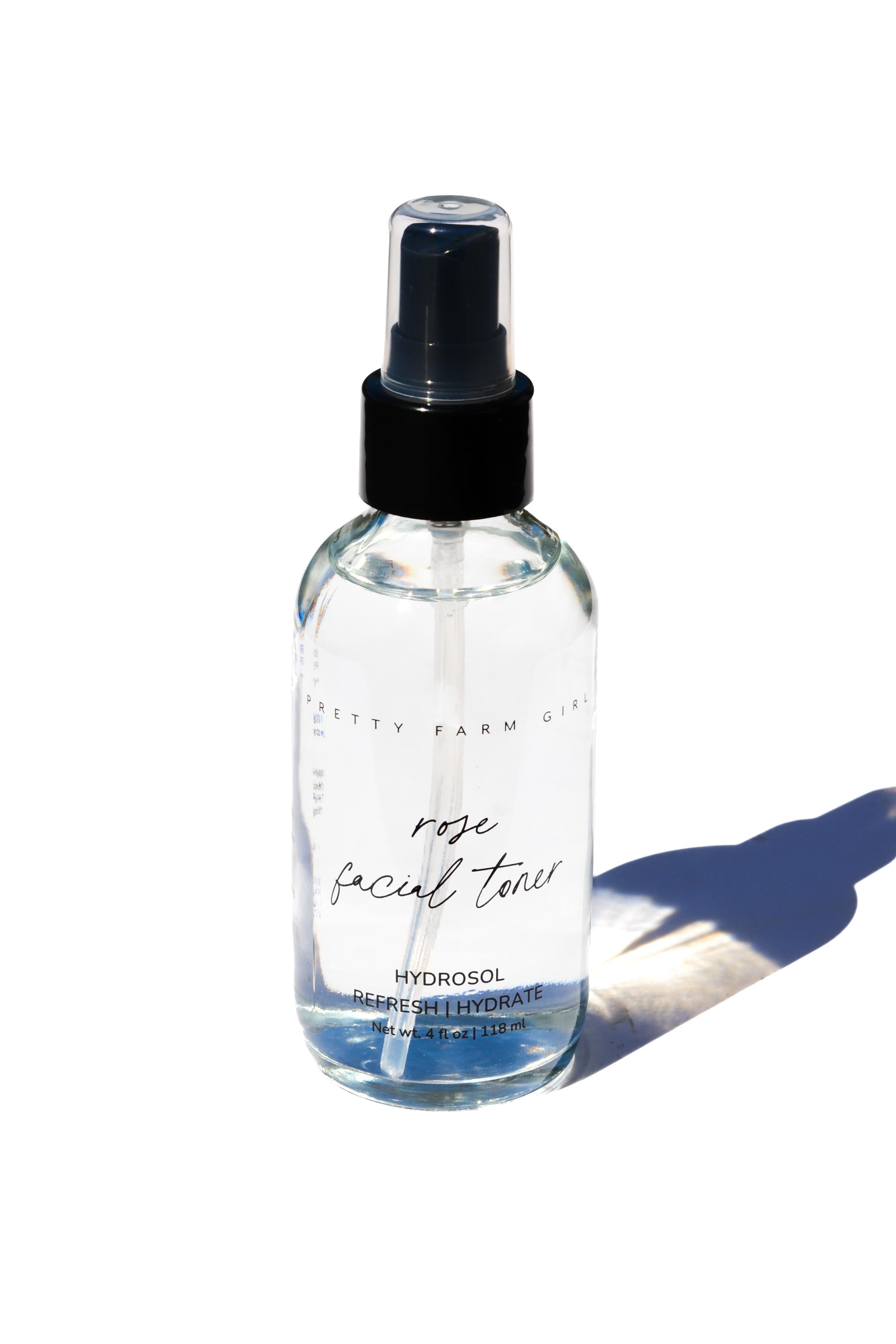 Organic Pure Rose Facial Toner by Pretty Farm Girl in a 2 oz bottle, showcasing the clear liquid and floral packaging.