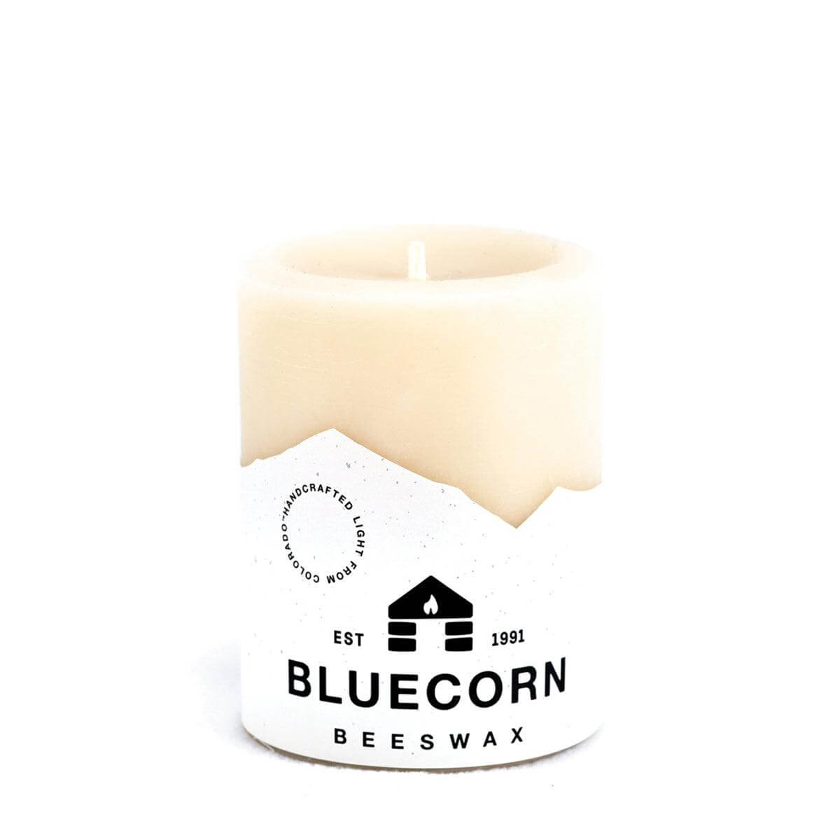 Ivory pure beeswax pillar candles by Bluecorn Candles, showing tall, smooth candles with natural beeswax texture and unlit wicks.