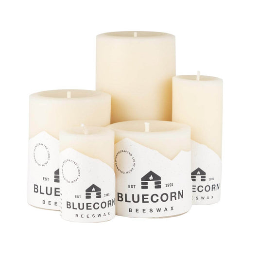 Ivory Pure Beeswax Pillar Candles by Bluecorn Candles, tall natural beeswax pillars with smooth surfaces on a wooden table