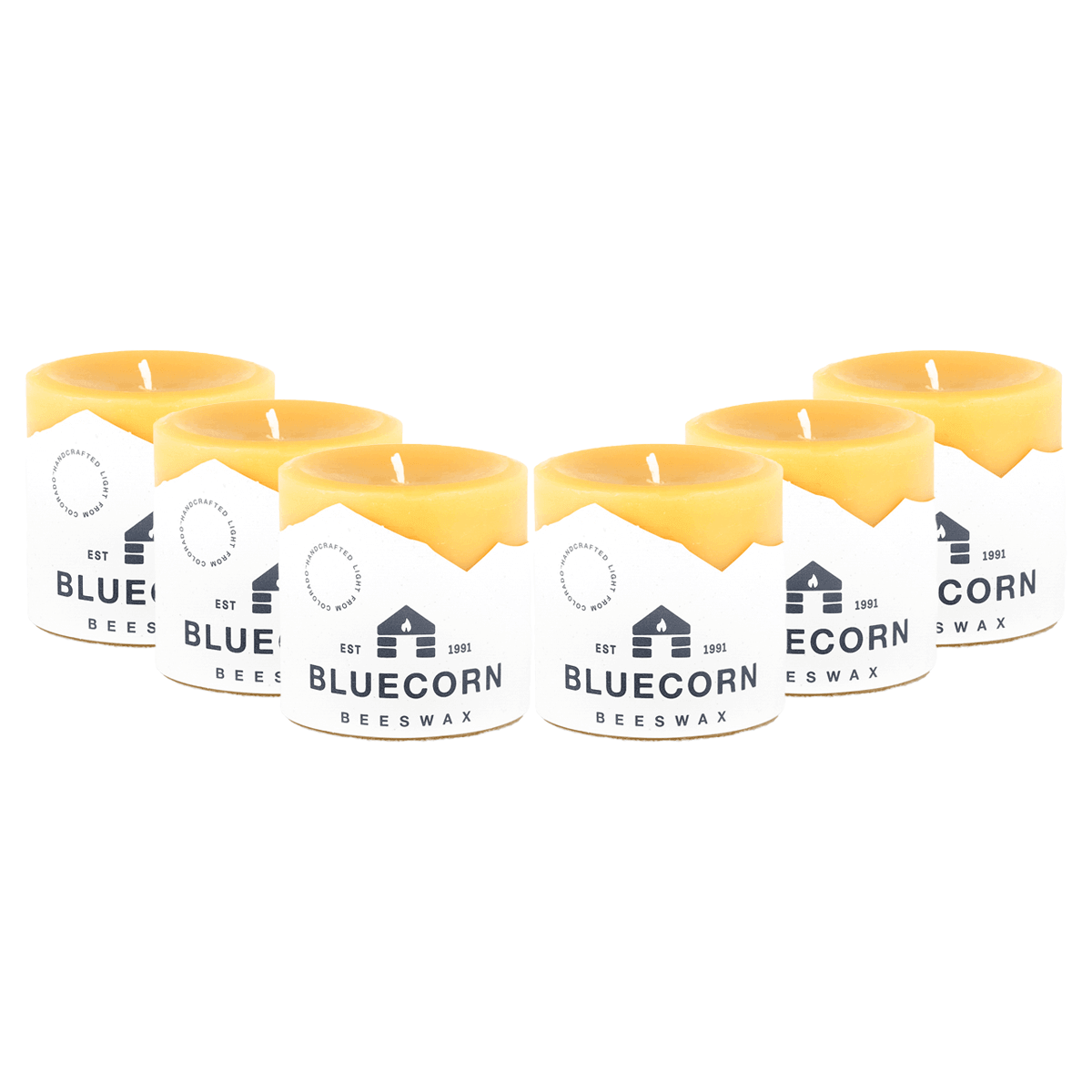 Pure beeswax pillar candles by Bluecorn Candles, showing tall, natural-colored candles with smooth surfaces and wicks visible.