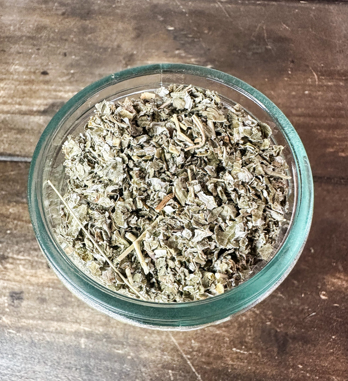 Small herb jars by HerbalRoseApothecary filled with dried herbs, including a raspberry-flavored herb jar, in a compact glass container