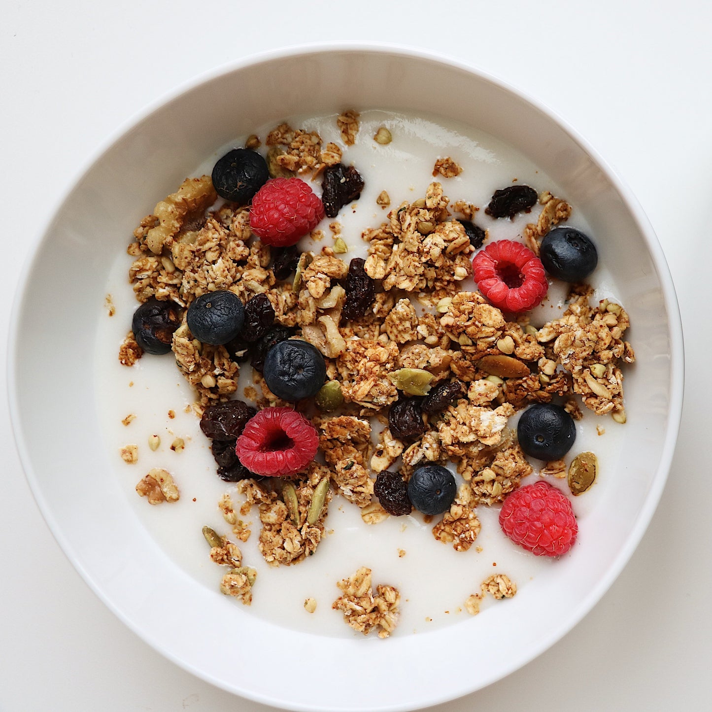 Rooted Living Maple Almond Granola in a bowl, showcasing toasted oats, almonds, and maple syrup for a hearty breakfast.
