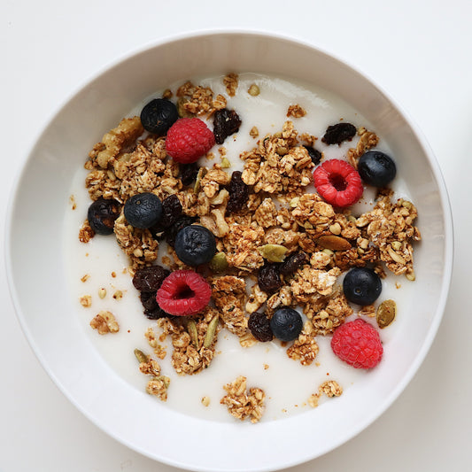 Bowl of Rooted Living Maple Almond Granola with almonds and oats, close-up showing toasted texture and maple flavor.