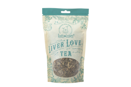 Herbal Liver Love Tea by Roots and Leaves LLC in a glass mug with dried herbs and tea leaves, brewed and ready to enjoy.