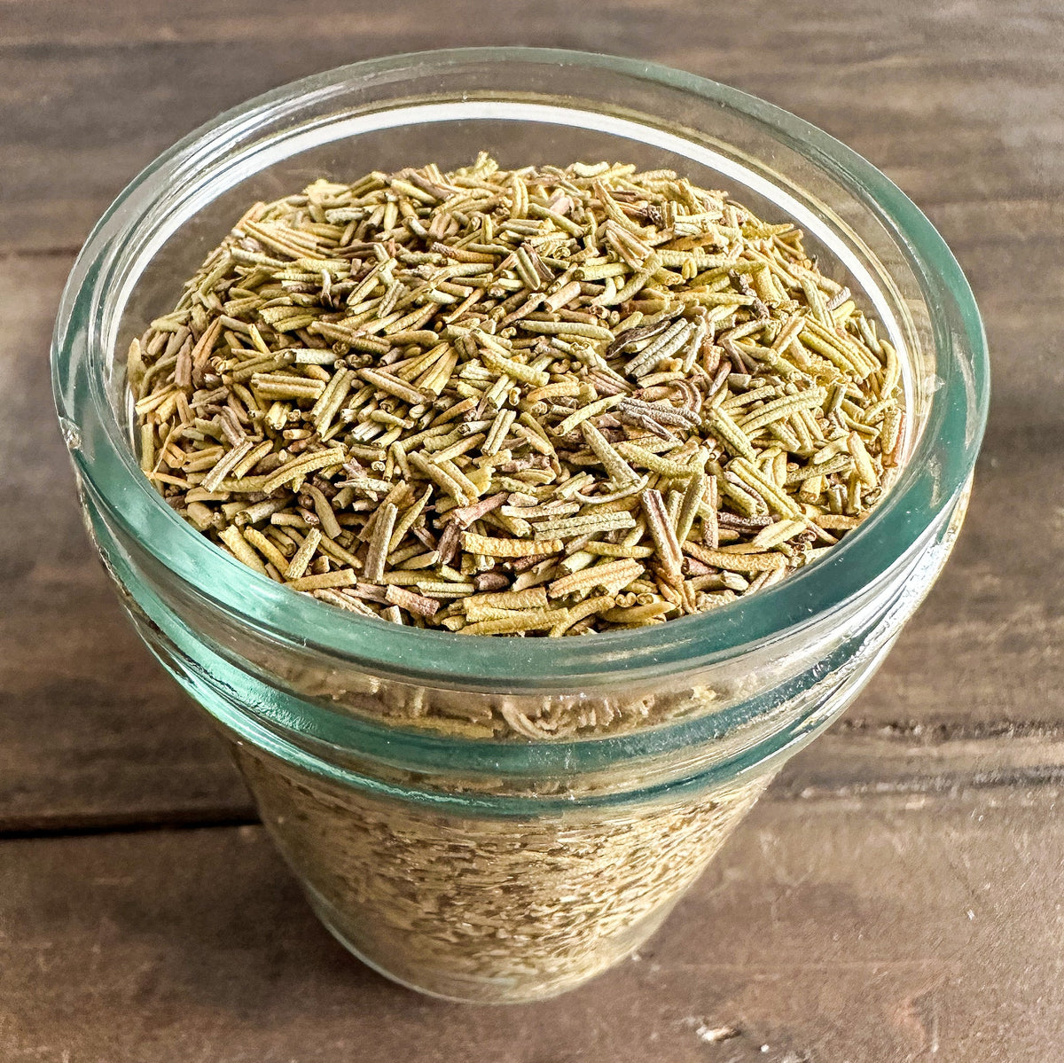 Small glass jar of dried rosemary herbs in herbalroseapothecary herb jars collection, with a label and metal lid.