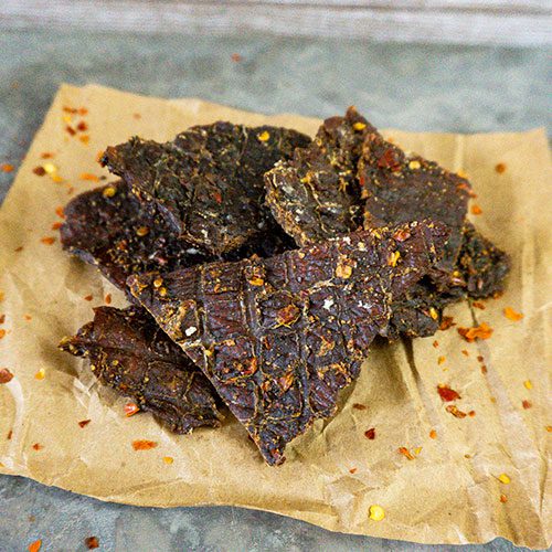 Red Pepper Beef Jerky from Nebraska Star Beef, 3 oz, with vibrant red pepper flakes visible on flavorful sliced beef.