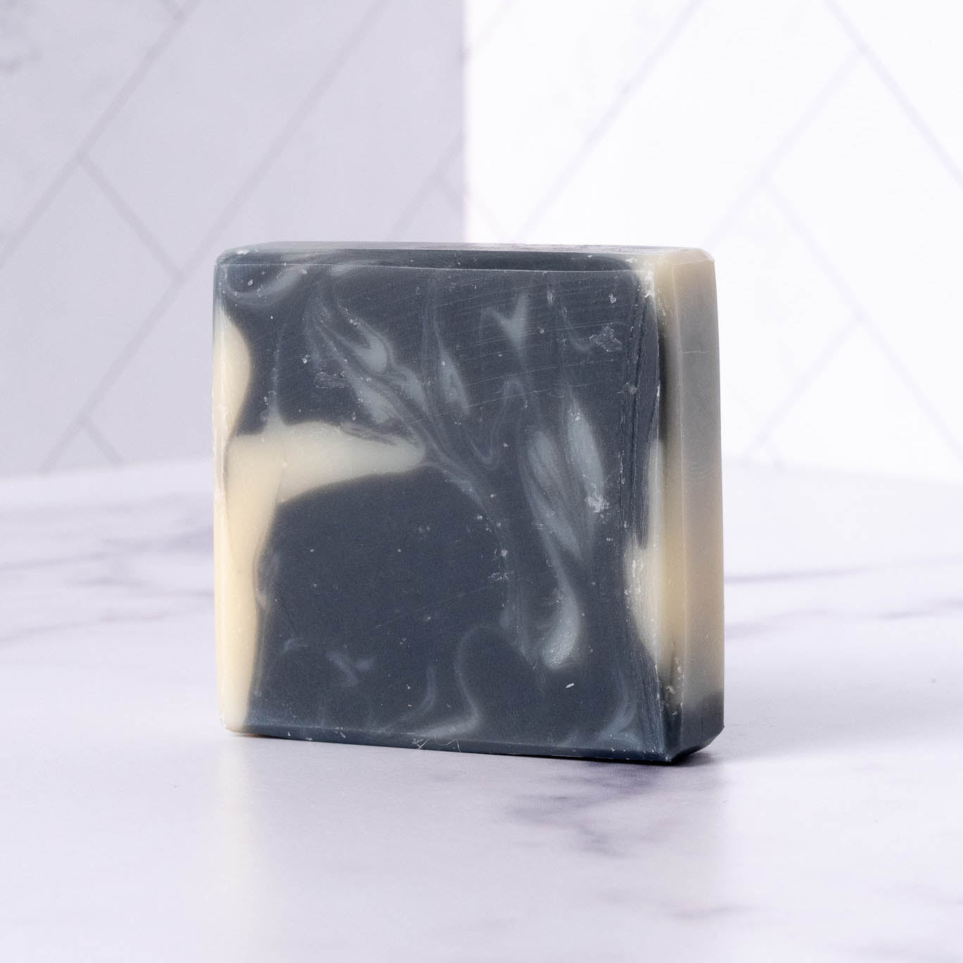 Rustic Strength detoxifying charcoal bar soap in a 2.5 oz bar, featuring a black, textured surface ideal for deep cleansing and skin refreshment.